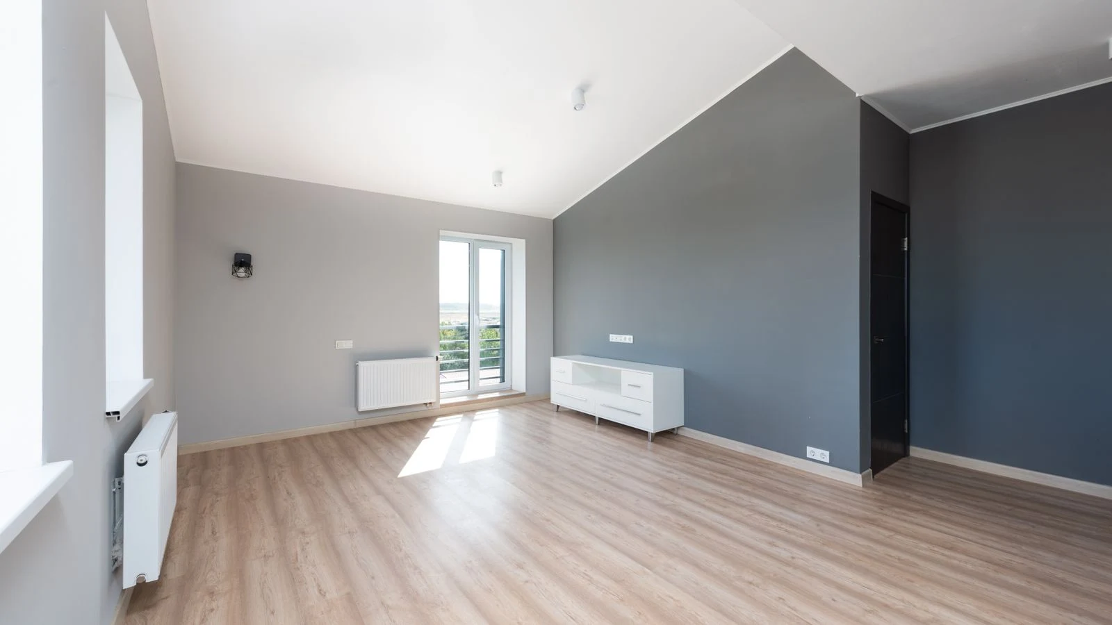Pièce vide avec parquet clair fraîchement posé et murs blancs